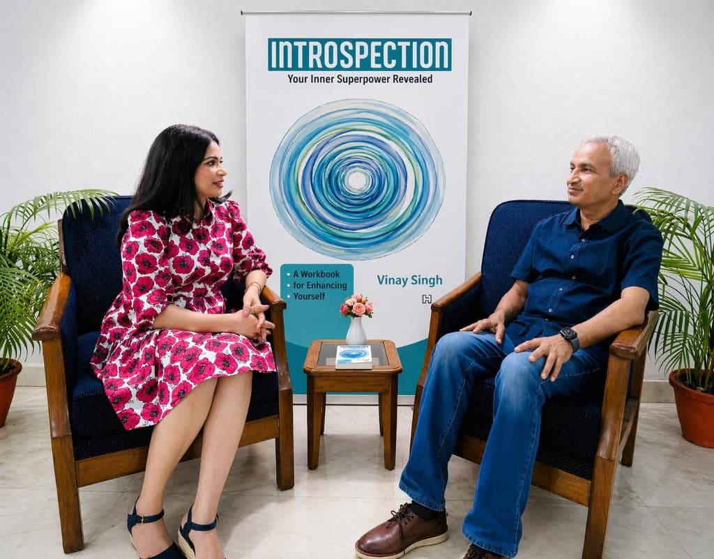 Vinay Singh in conversation with an anchor beside the Introspection book display